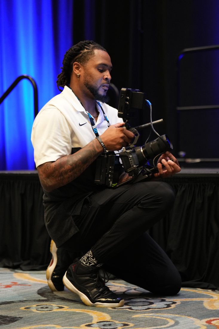 Kyle Prater kneeling with camera on set